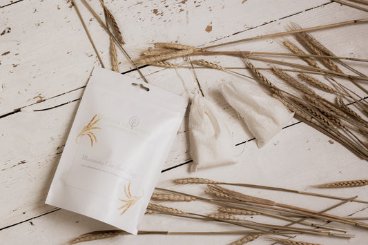 White product packaging with gold accents on a wooden surface with wheat stalks.