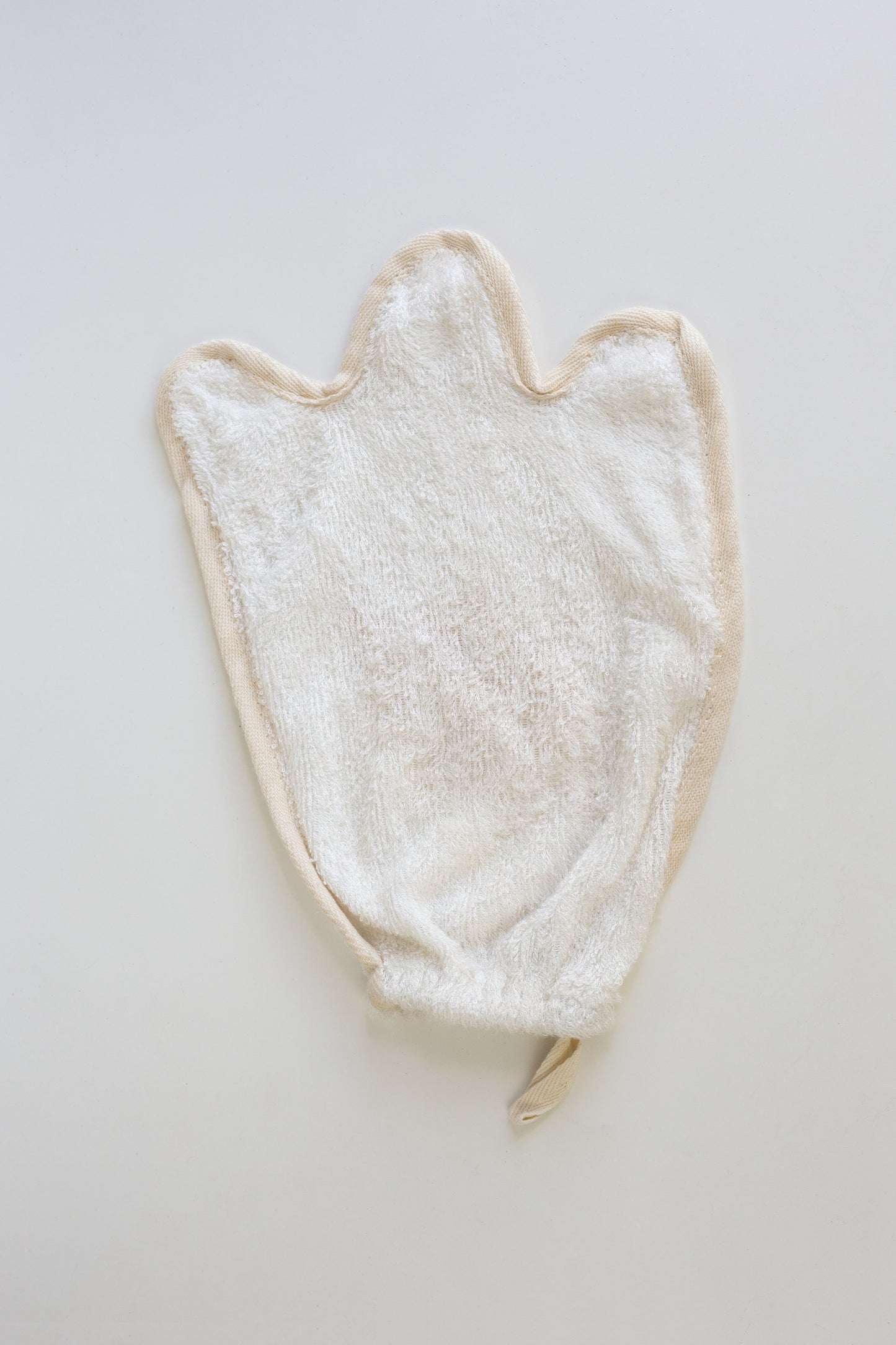 White towel/Mitt/flannal with a ghost shape on a light gray background
