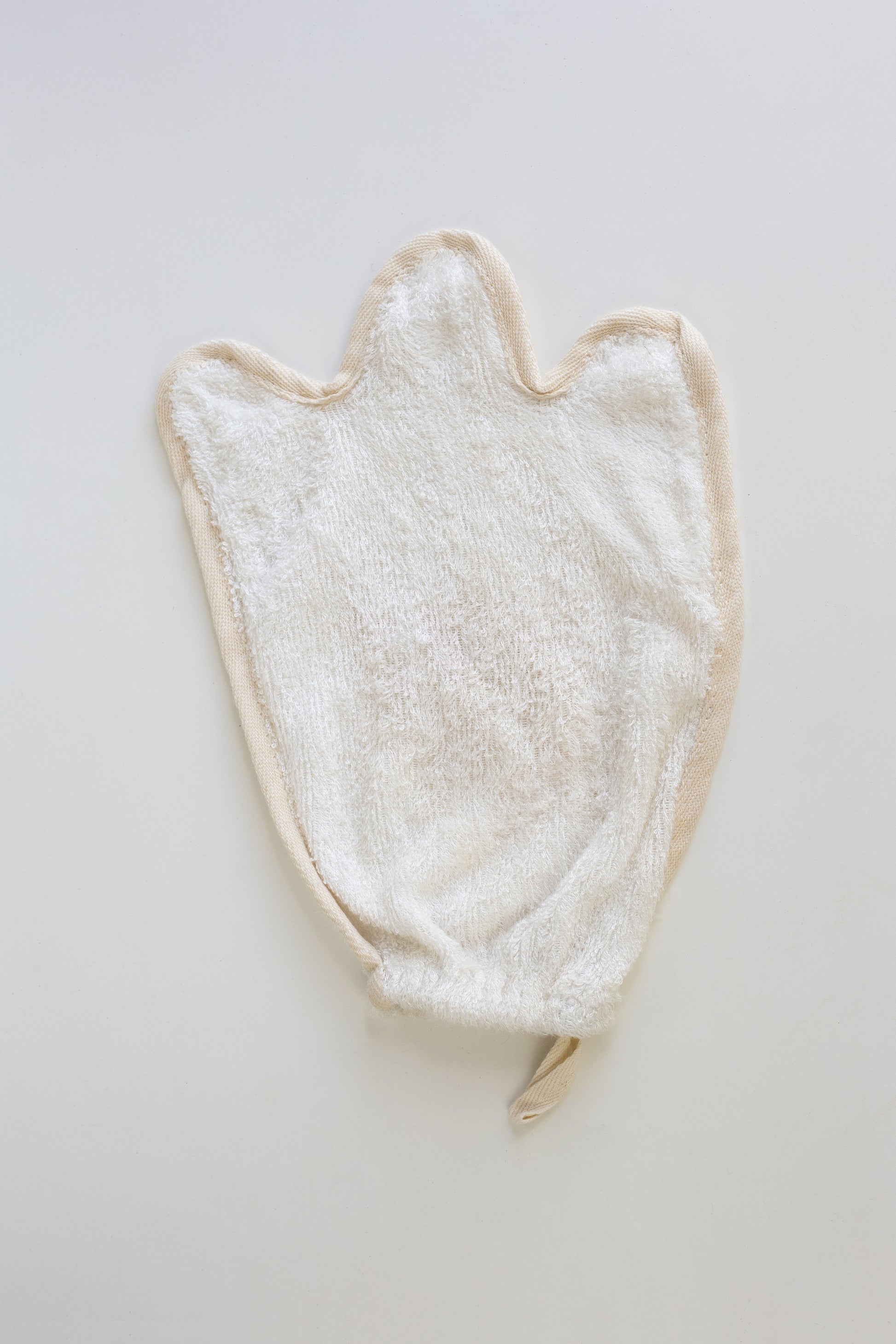 White towel/Mitt/flannal with a ghost shape on a light gray background