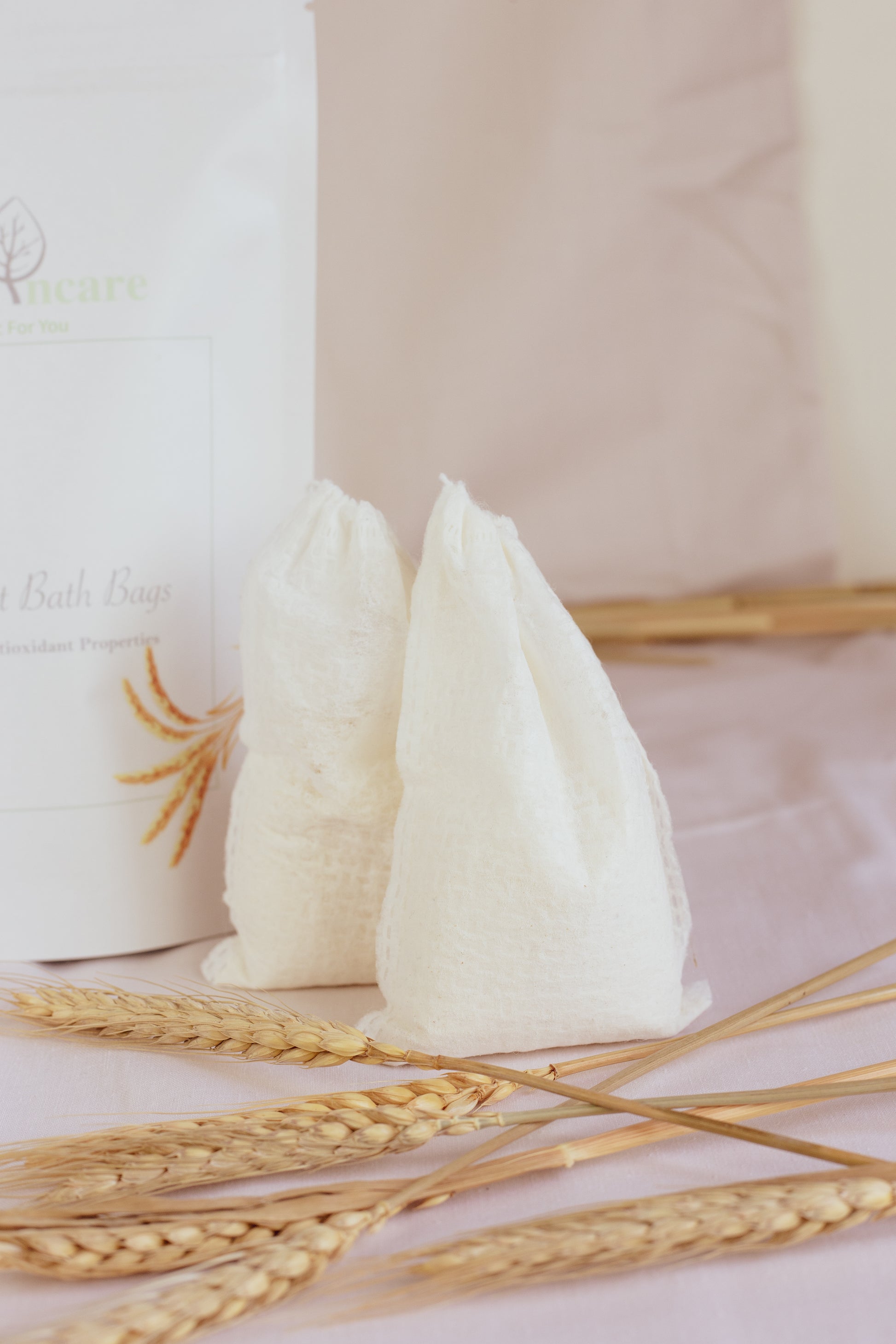 White bags with wheat stalks on a light pink background
